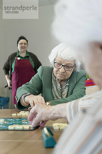 Senioren spielen Brettspiel im Seniorenheim