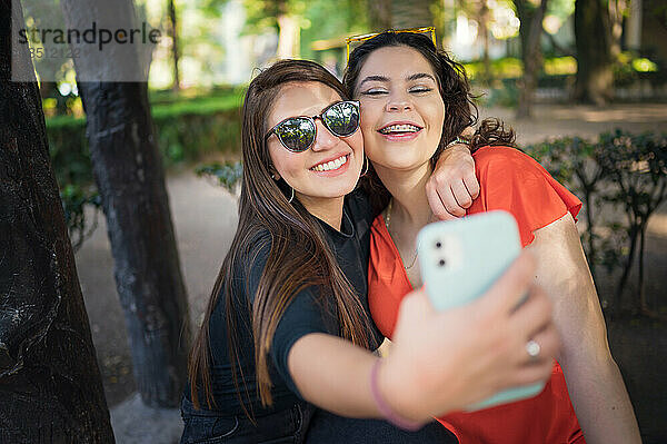 Zwei junge lateinamerikanische Freundinnen gehen im Wald spazieren