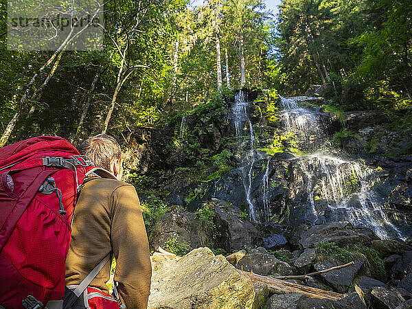 Männlicher Wanderer bewundert den Wasserfall im Schwarzwald  Baden-Württemberg  Deutschland