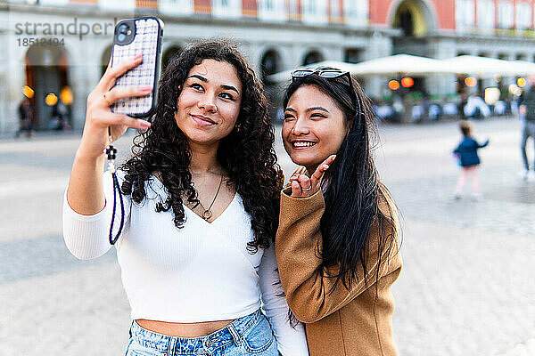 Stockfoto von glücklichen Freunden  die mit dem Telefon fotografieren