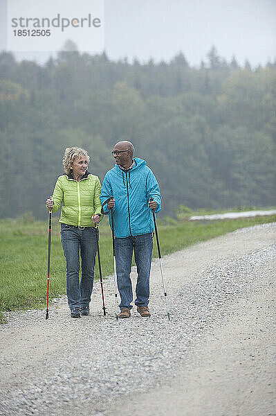Älteres Paar beim Wandern mit Wanderstöcken  Bayern  Deutschland