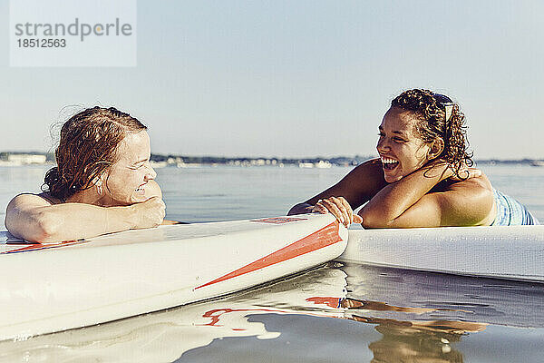 Zwei junge Freundinnen entspannen sich auf Standup-Paddle-Boards in Casco Bay