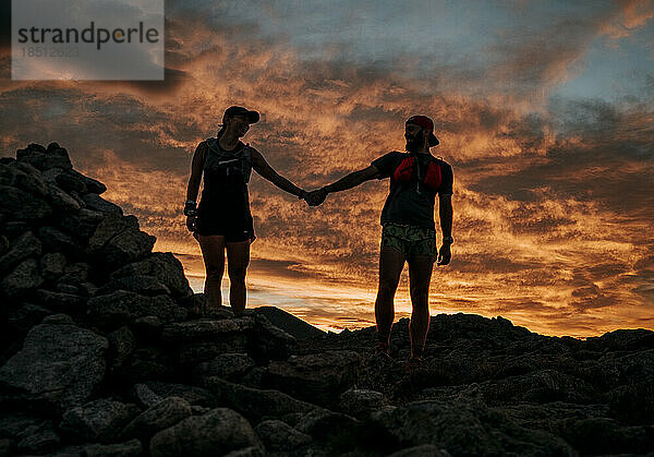 Paar hält Händchen vor farbenprächtigem Sonnenaufgang  Katahdin  Maine