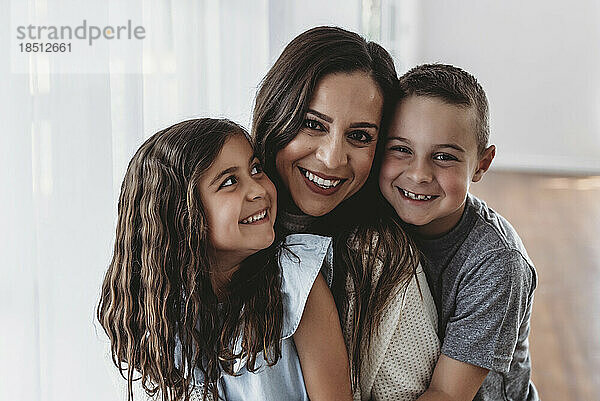 Porträt einer liebevoll lächelnden Familie im Studio mit natürlichem Licht