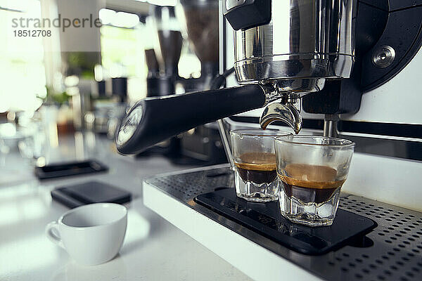 Zwei Espresso-Shots werden aus einer Maschine in Gläser gefüllt.