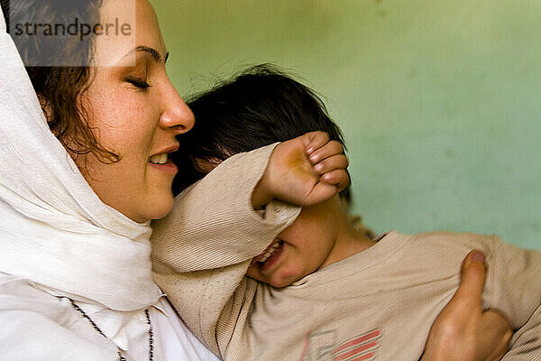 Frau tröstet ein weinendes Kind in Kabul  Afghanistan.