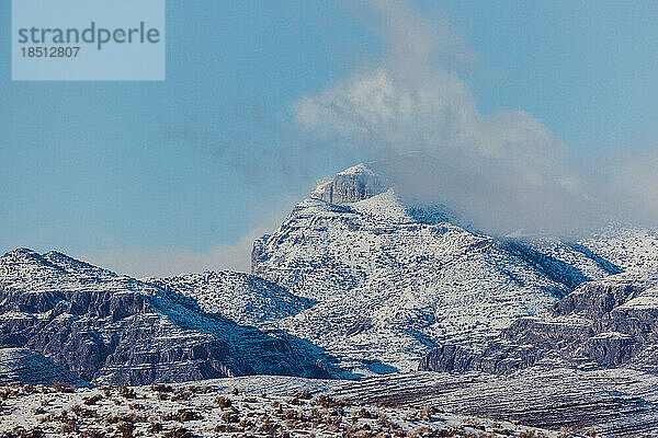 In der Ferne stehen schroffe  schneebedeckte Berge.