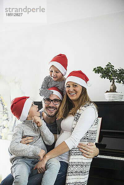 Porträt einer Familie mit Weihnachtsmütze  München  Deutschland