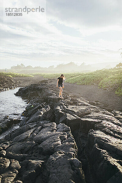 Ein Mädchen läuft auf Lavafelsen in der Nähe des Ozeans  Big Island  Hawaii.