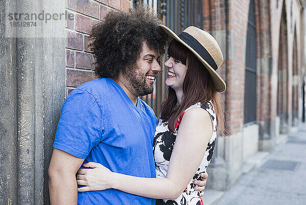 Glückliches junges Paar  das sich draußen in der Stadt umarmt