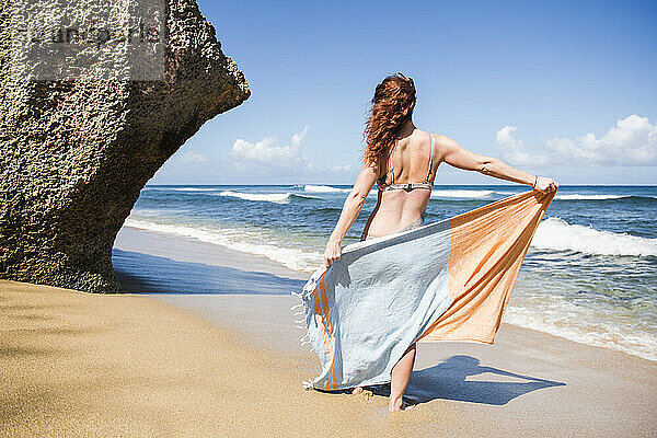 Solo-Frau im Bikini mit Handtuch am Strand in Puerto Rico