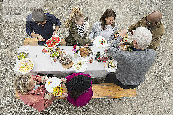 Blick aus der Vogelperspektive auf Familie und Freunde  die eine Party im Freien auf einem Bauernhof in Bayern genießen
