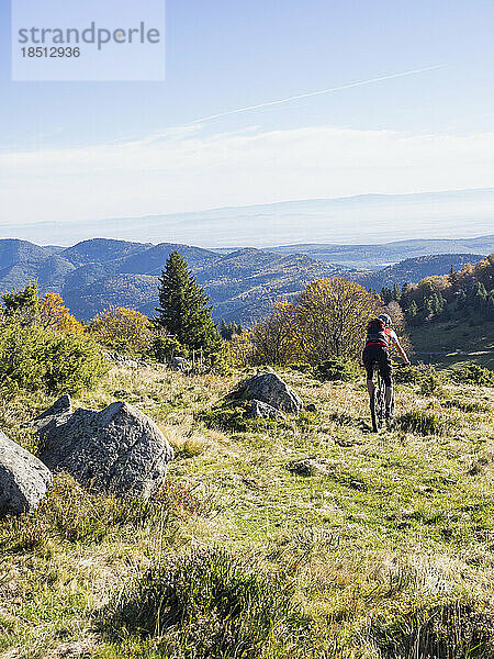 Mann fährt mit Elektro-Mountainbike auf Radtour in den Vogesen  Frankreich