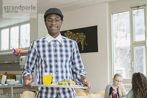 Universitätsstudent mit seinem Mittagessen auf dem Teller und lächelnder Schule  Bayern  Deutschland