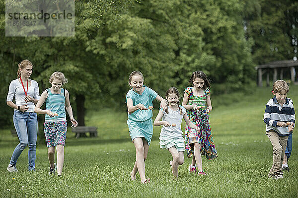 Gruppe von Kindern  die an einem Ei-und-Löffel-Rennen im Park  München  Bayern  Deutschland  teilnehmen