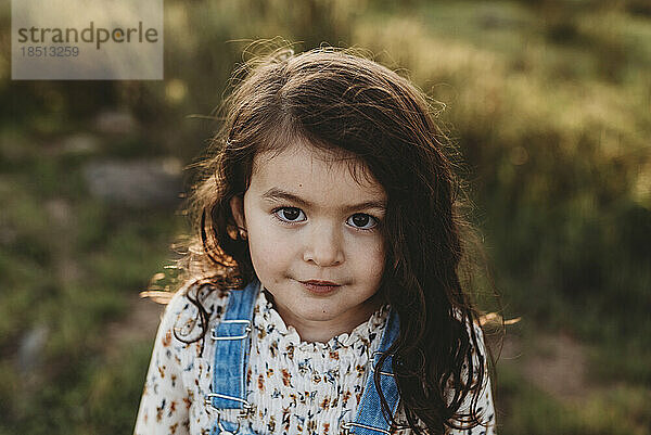 Ernsthaftes Porträt eines jungen Mädchens im schulpflichtigen Alter mit Sonnenlicht im Haar