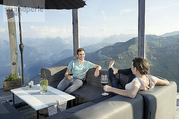 Junges Paar trinkt Wein auf der Terrasse  Zillertal  Tirol  Österreich