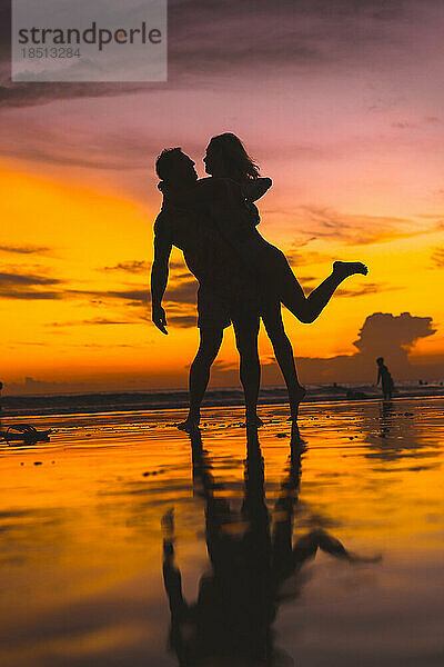 Paar hat Spaß am Meeresstrand. Sonnenuntergang auf Bali.