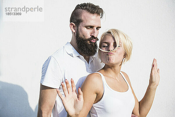 Junger Mann mit seiner verspielten Freundin macht Schnurrbart mit Haaren  Bayern  Deutschland