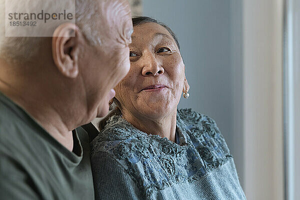 Glückliches älteres Paar zu Hause neben dem Fenster