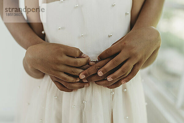 Close up of sisters' hands intertwined in studio