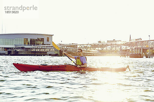 Mann paddelt auf einer Kajaktour durch die Casco Bay bei Sonnenuntergang in Portland  Maine