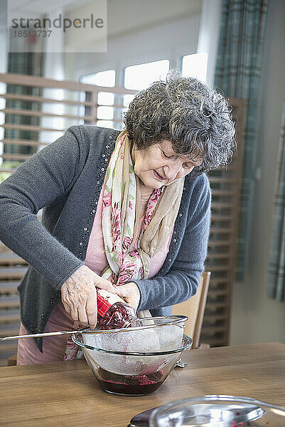 Ältere Frau bereitet Dessert im Pflegeheim zu