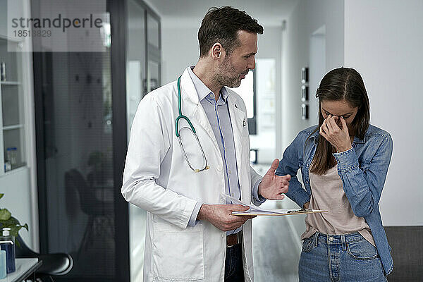 Gestresste Frau diskutiert mit Arzt in der Klinik