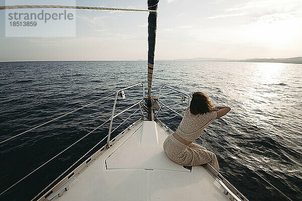 Woman leaning on railing of sailboat