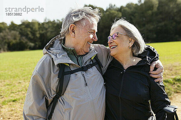 Liebevolles älteres Paar  das mit umgelegtem Arm in der Natur steht