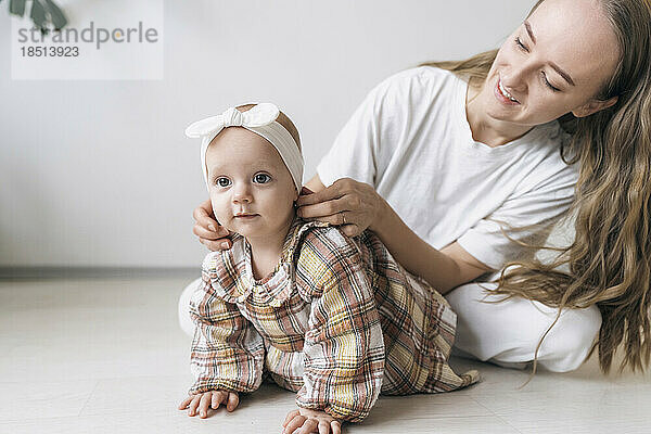 Lächelnde Mutter passt das Stirnband am Kopf ihrer Tochter an
