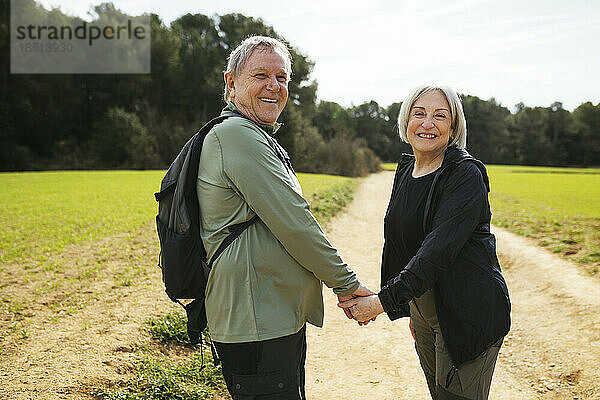 Glückliches älteres Paar beim Wandern  Händchen haltend in der Natur