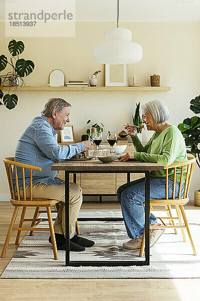 Glückliches älteres Paar genießt das Mittagessen zu Hause