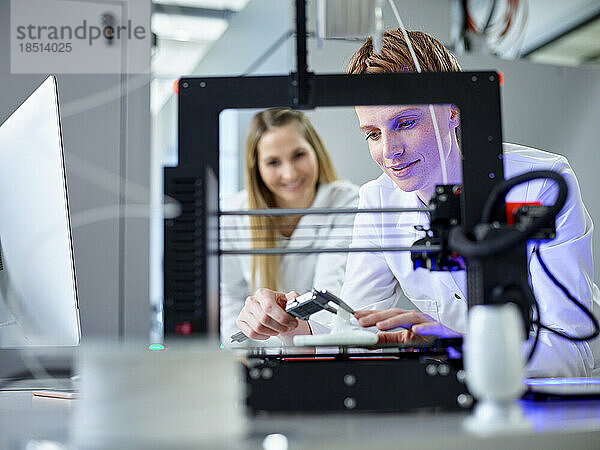 Ingenieur und Kollege bedienen 3D-Druckmaschine im Labor
