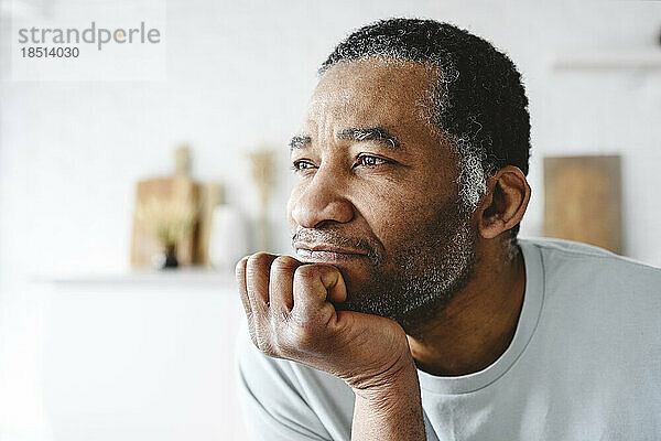 Contemplative mature man with hand on chin