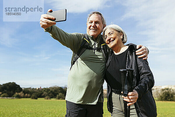 Älterer Mann macht an einem sonnigen Tag ein Selfie mit einer Frau