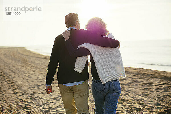 Liebevolles älteres Paar  das gemeinsam am Strand spaziert