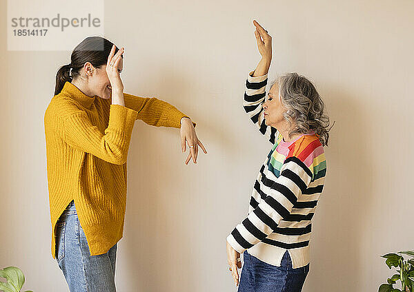Sorglose Mutter und Tochter tanzen an der Wand