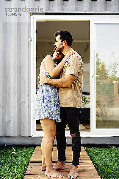 Romantisches Paar umarmt sich vor dem Containerhaus
