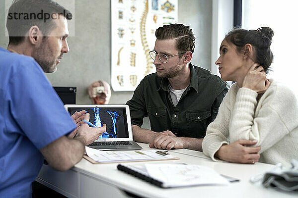 Arzt diskutiert mit Paar über medizinisches Röntgen