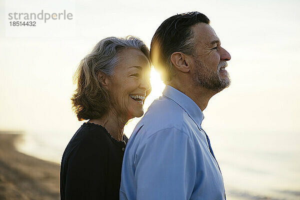 Glückliches älteres Paar  das zusammen am Strand steht