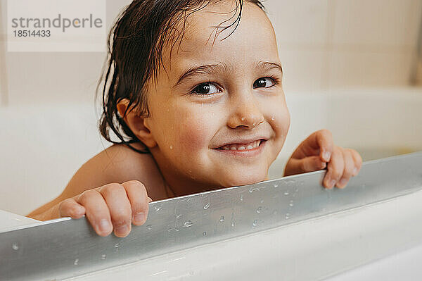 Netter Junge  der in der Badewanne badet