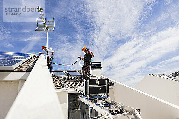 Techniker arbeiten auf dem Dach zusammen