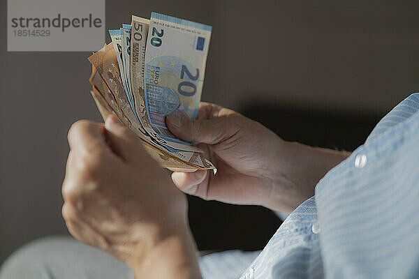 Hände eines älteren Mannes  der die europäische Papierwährung zählt