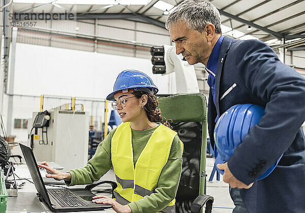 Ingenieure diskutieren über Laptop in der Industrie