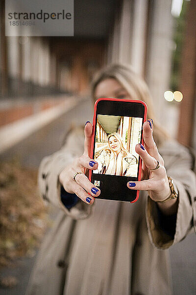 Frau macht Selfie über Smartphone-Bildschirm