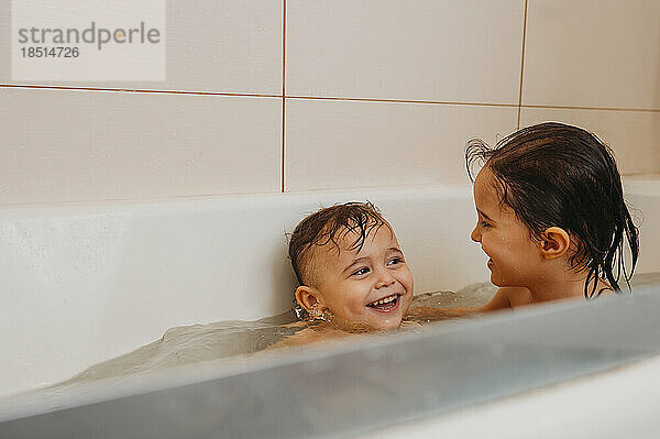 Brothers playing in bathtub at home