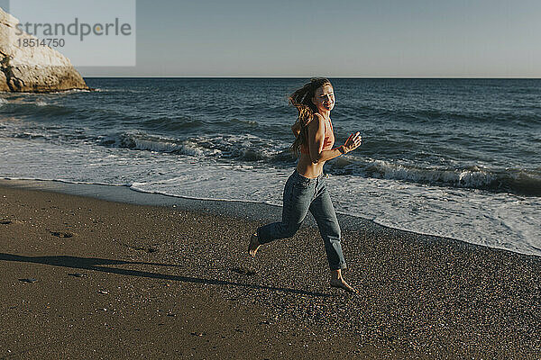 Glückliche Frau läuft am Strand
