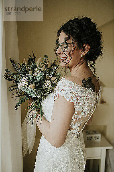 Glückliche Braut hält Blumenstrauß