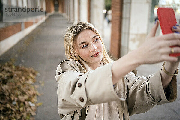 Frau macht Selfie mit Smartphone auf Fußweg